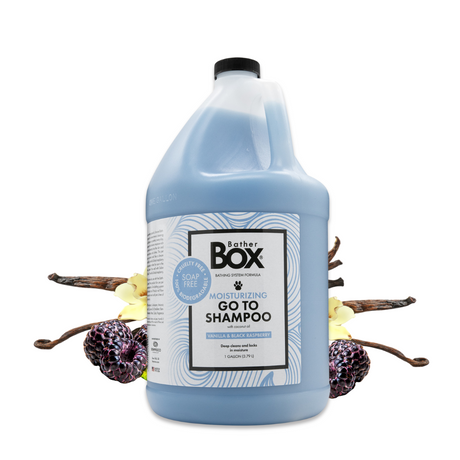Gallon jug of BatherBox® Go To Shampoo displayed with vanilla pods and ripe black raspberries