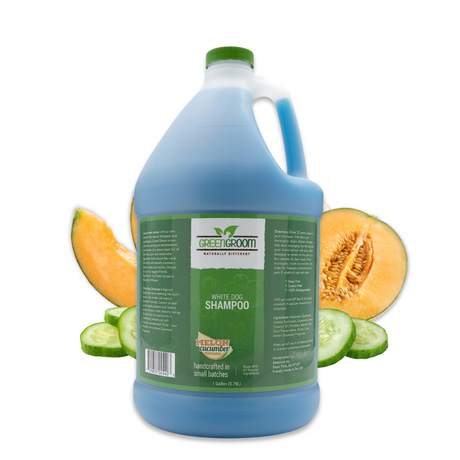 Gallon jug of Green Groom White Dog Shampoo surrounded by cucumber rounds and fresh cantaloupe