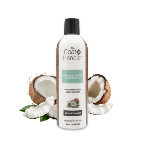 16 oz bottle of The Coat Handler Undercoat Control DeShedding Conditioner displayed with freshly cracked coconuts