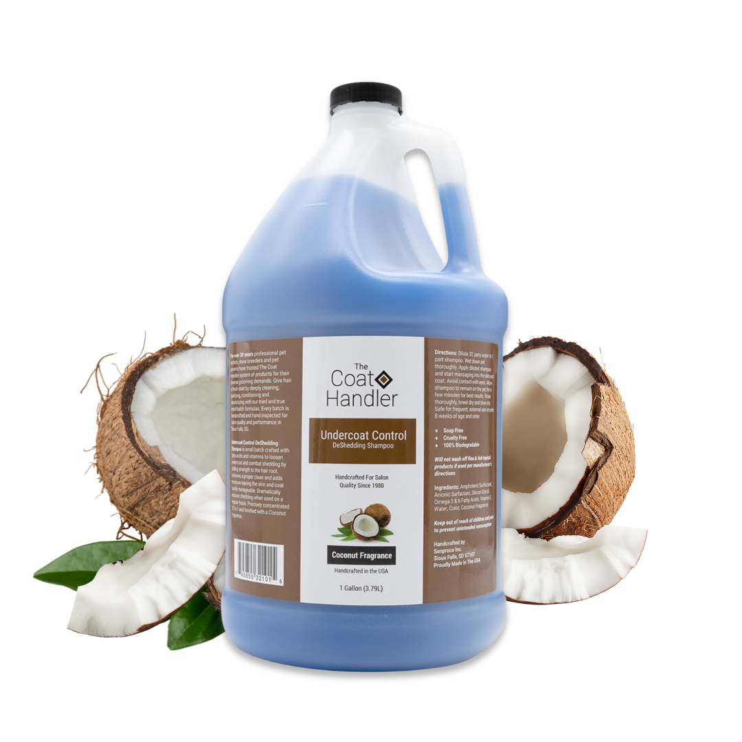 Gallon jug of The Coat Handler Undercoat Control DeShedding Shampoo displayed with freshly cracked coconuts