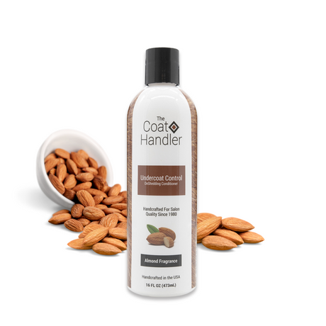 16 oz bottle of The Coat Handler Undercoat Control DeShedding Conditioner displayed with whole almonds spilling from a white bowl