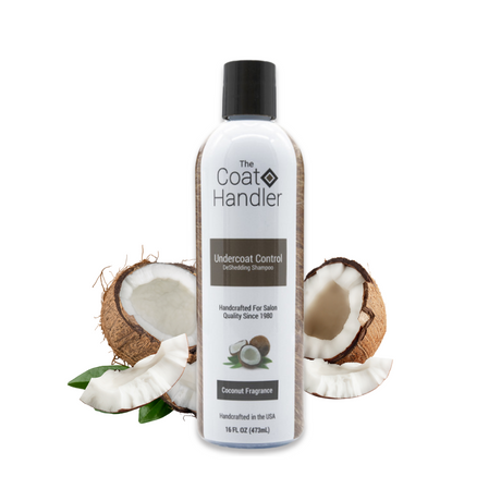 16 oz bottle of The Coat Handler Undercoat Control DeShedding Shampoo displayed with freshly cracked coconuts